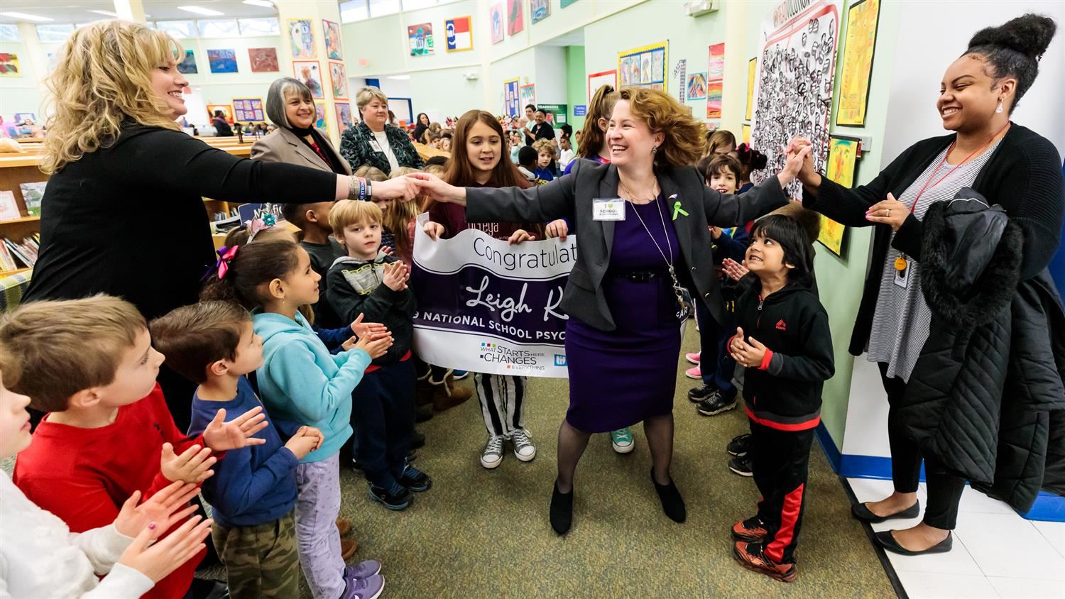 Leigh Kokenes giving high fives to teachers 